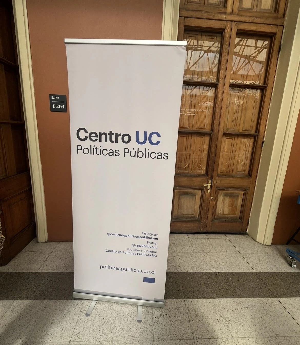 Banner del Centro de Políticas Públicas UC en el ingreso al seminario